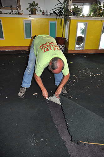 Rev. Bob Allen cutting out flooded carpet from a flooded building in Holly Hill, SC.